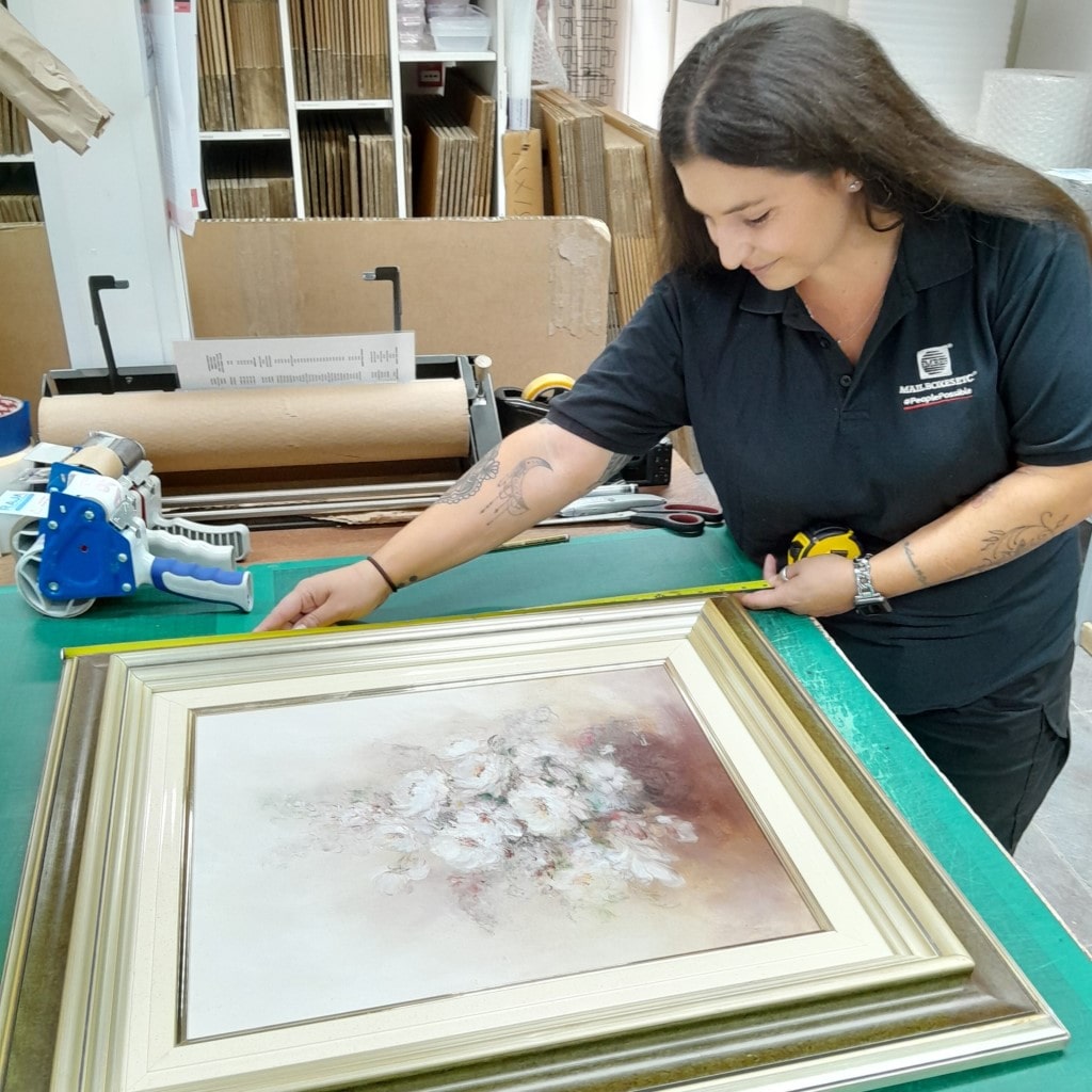 MBE Chichester team member Abi measuring a photo frame